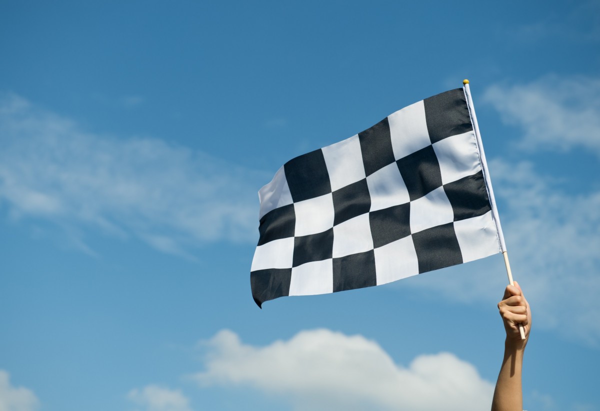 Hand holding a racing flag in the air
